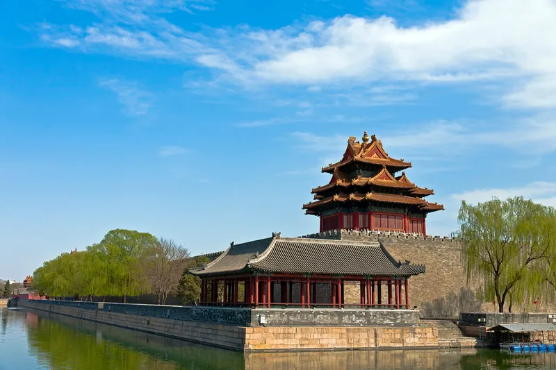 Golden rooftops of the Forbidden City stretching into the distance under a clear autumn sky in Beijing