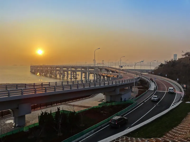 Dalian's Xinghai Bay bridge curving along the coastline over blue water