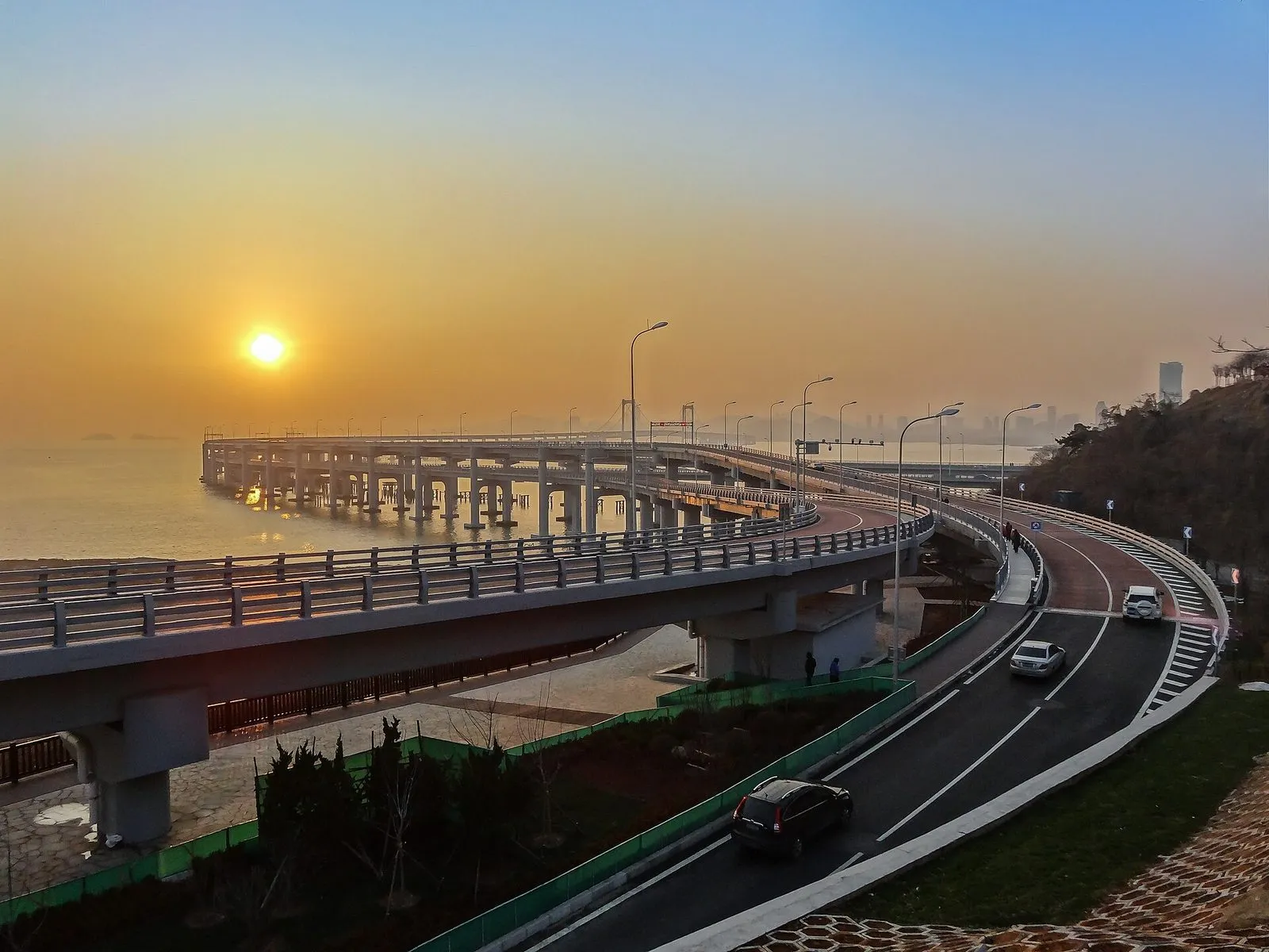 Dalian's Xinghai Bay bridge curving along the coastline over blue water