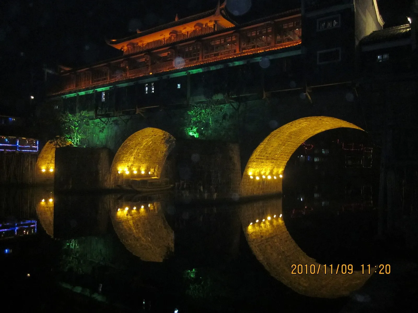 The Tuojiang River and Hong Bridge in Fenghuang Ancient Town at night, lanterns reflected in the water