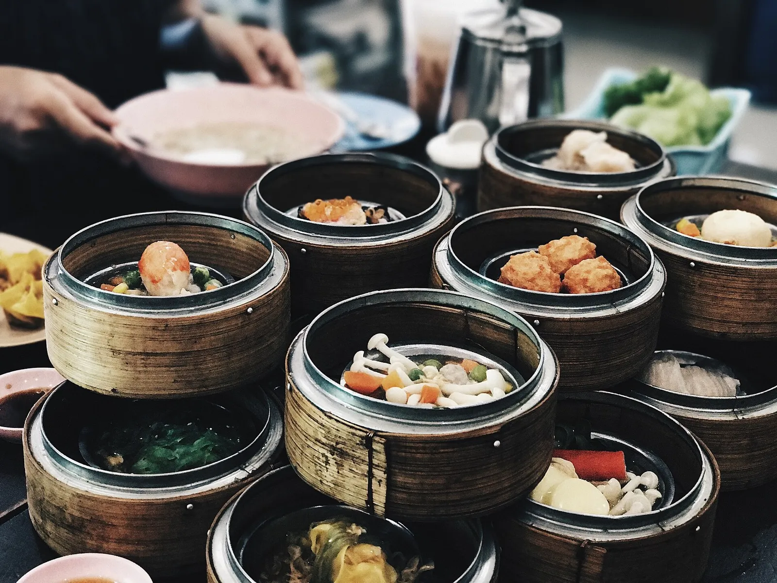 A steaming table of Chinese dishes — dumplings, noodles, and hotpot — shared family style