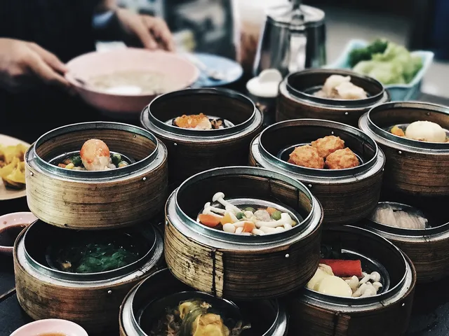 A steaming table of Chinese dishes — dumplings, noodles, and hotpot — shared family style
