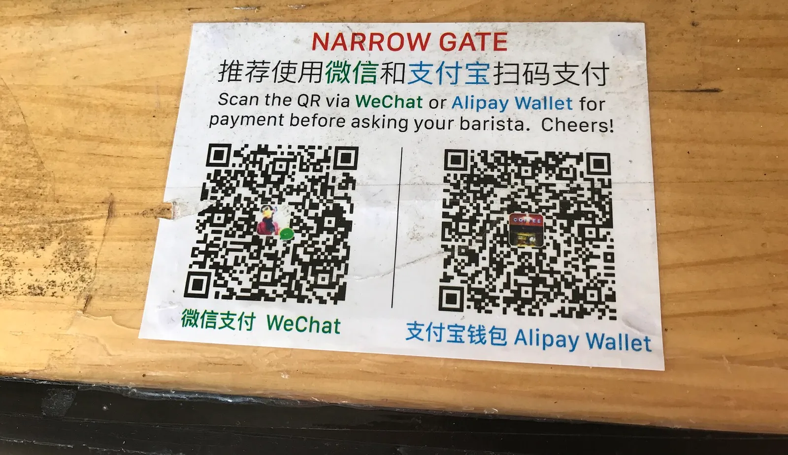 A phone showing a QR payment screen held over a market stall counter in China