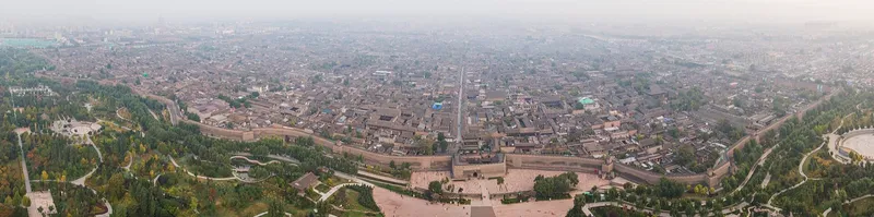 Lantern-lined street and city gate of the walled old town of Pingyao at dusk