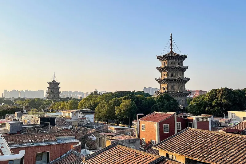 The twin stone pagodas of Kaiyuan Temple rising over the red-roofed old town of Quanzhou