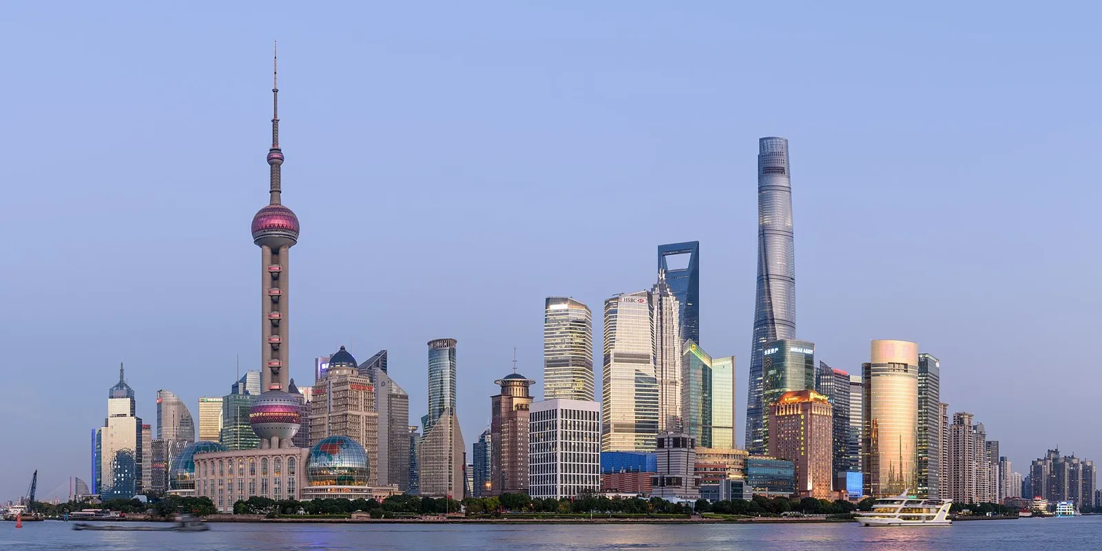 The Bund riverfront at dusk with the illuminated Pudong skyline across the Huangpu River