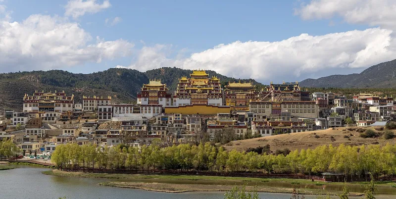 Songzanlin Monastery reflected in the lamuyangcuo lake under a clear Shangri-La sky
